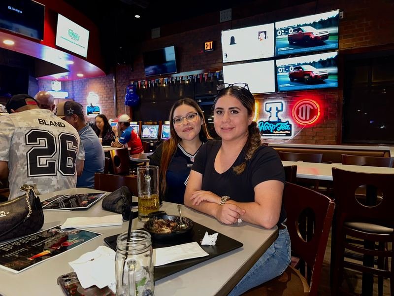 Game Day Friends: Friends grabbing a table with the game on.