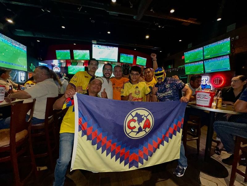 Club América Flag: Fans proudly hold up the Club América flag.